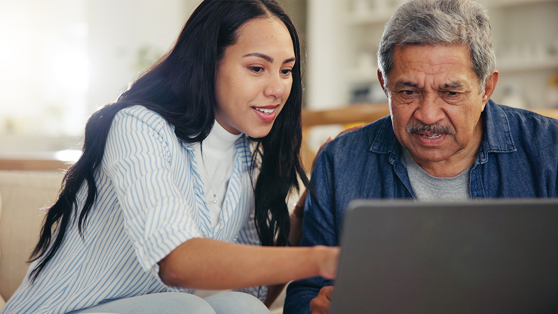Family caregiver helping elderly parent with digital safety